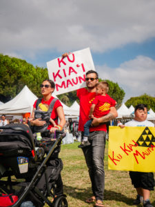 a family carries "ku kia'i mauna" signs